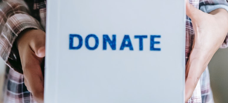 A person holding a box that says donate