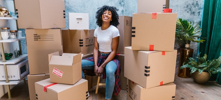 Woman sitting among packed boxes