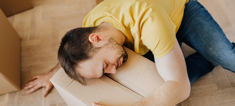 A man taking a nap on a cardboard box on the moving day