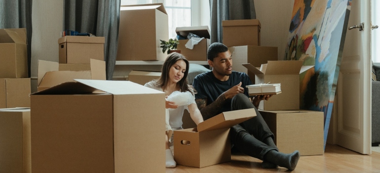 two people packing their boxes for the move and thinking about ways to save money on long-distance relocation from Queens