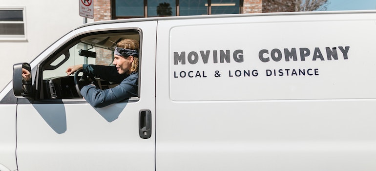 A man in a van that says Moving Company