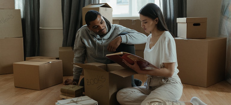 couple packing their photo albums while waiting for movers Forest Hills