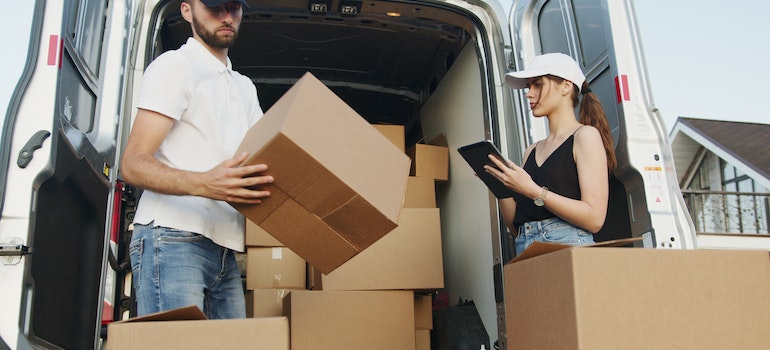 Professional movers loading a van with boxes;