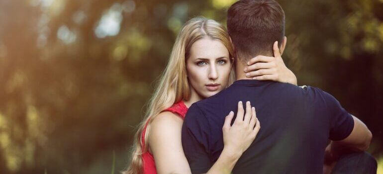 A woman hugging her boyfriend and thinking about where to go for Valentines Day in NYC.