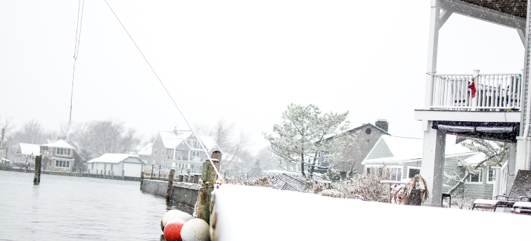 House by the water with snow everywhere with a person wondering about living expenses for a family in Long Island.