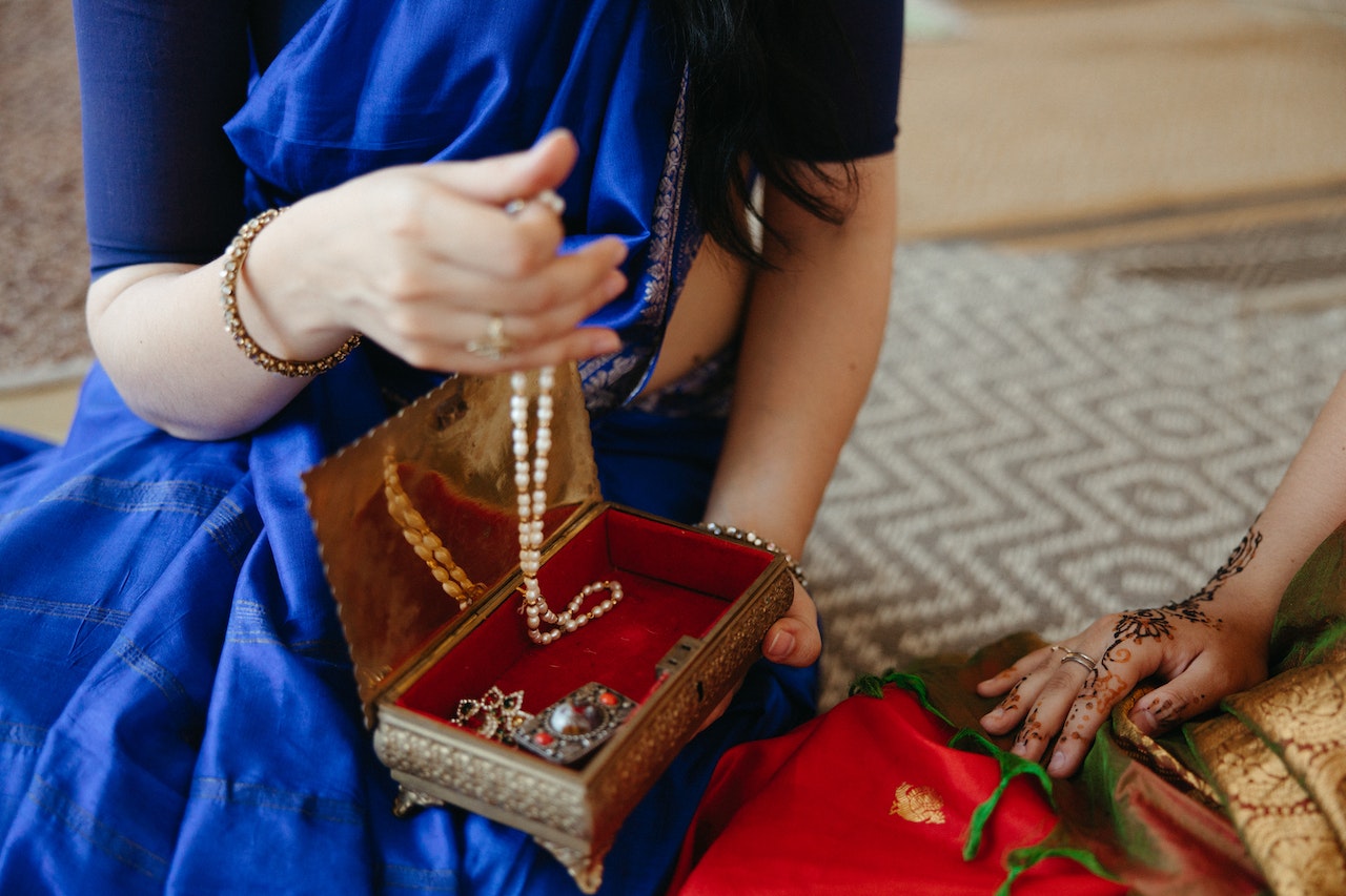 A woman storing jewelry in a box.