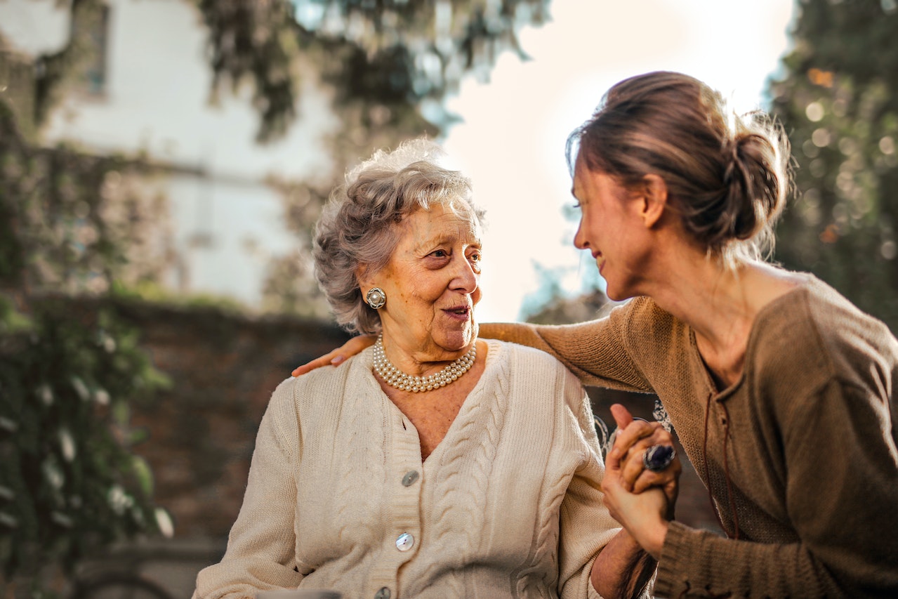 Elderly woman and her daughter talking.