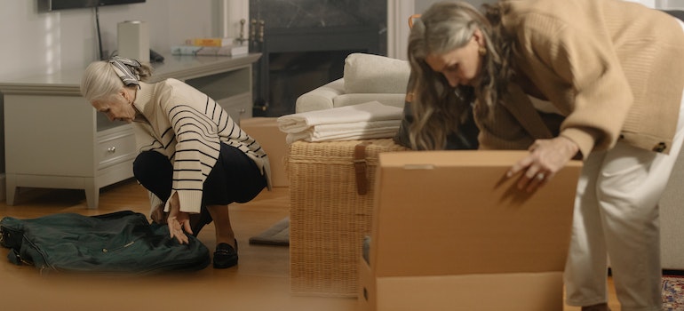 Two elderly women packing for the move.