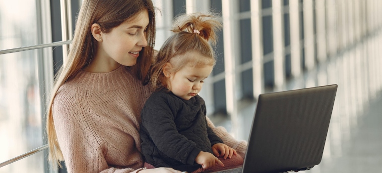 A mother and her daughter using a lap top to check for some ways to connect with your new neighborhood in Brooklyn.
