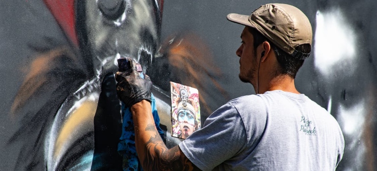 An artist painting on a wall.