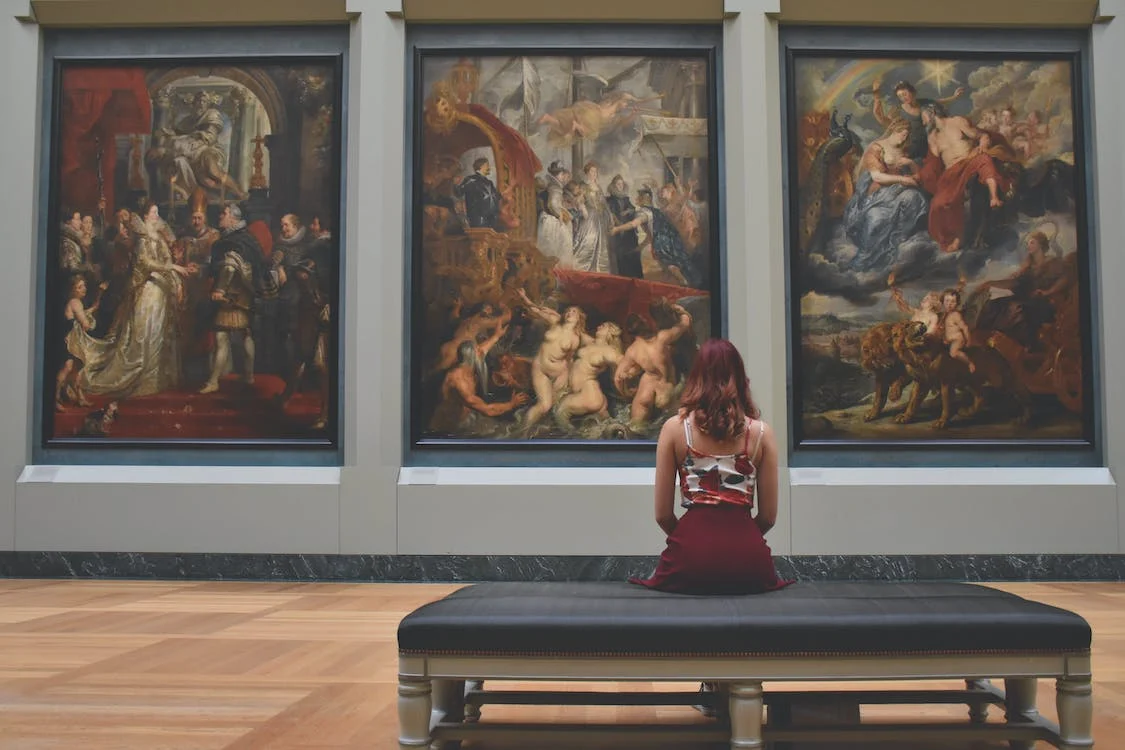A woman looking at some paintings.