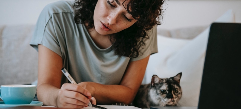 a woman preparing a plan for moving to Manhattan with a cat