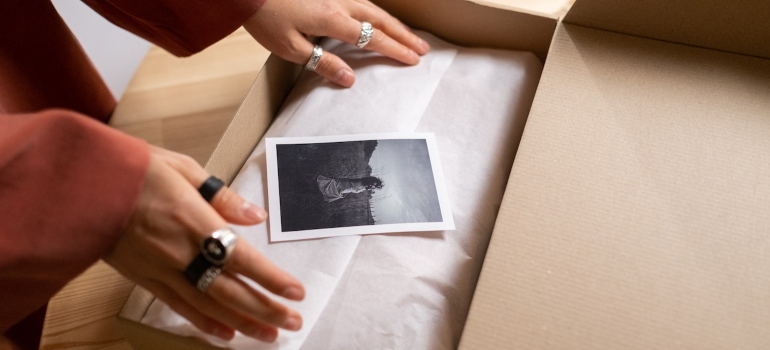a person packing a photograph about to store artwork in a Park Slope storage 